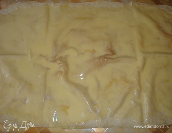 Лаваши раскатать, сложить один на один и смазать их равномерно яично-сахарной смесью.