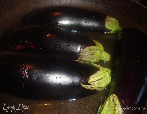 Баклажаны смыть под водой, подсушить. Обжарить по 5 минут с каждой стороны на оливковом масле. Мякоть выбрать чайной ложкой  и мелко нарезать.