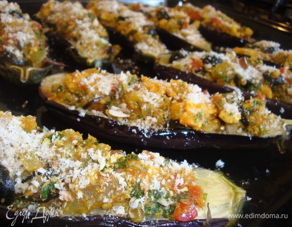 На противень выложить баклажаны, начинить их начинкой, присыпать миндалем. Запекать в разогретой до 180 градусов духовки 20 минут.