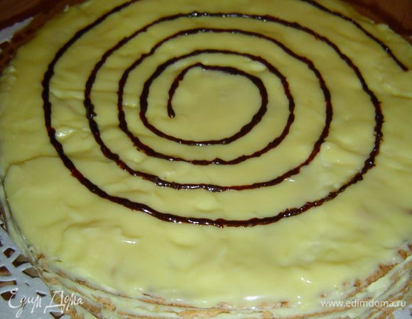  Затем растопим черный шоколад, поместим его в корнетик и сделаем на торте рисунок ввиде спирали, а затем зубочисткой проводим линии перпендикулярно спирали и получаем паутинки.
