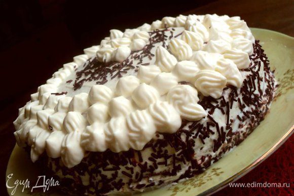 Бока и верх торта украсить оставшимся кремом, посыпать тертым шоколадом или шоколадной посыпкой.