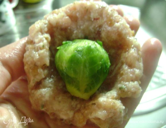 Сформировать из кусочка фарша лепешку, в центр которой положить кочанчик капусты.