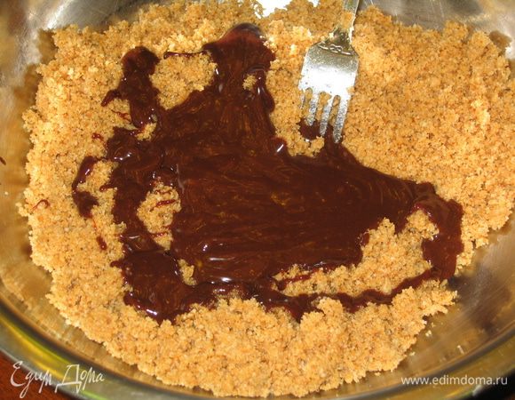 Добавить растопленный шоколад к крошке и тщательно перемешать
