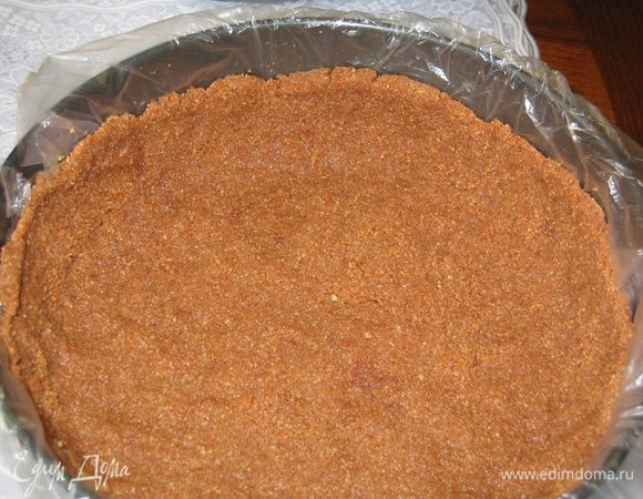 В форму с разъемными бортиками устелить пленку, разложить на дно тесто и приподнять края пальцами