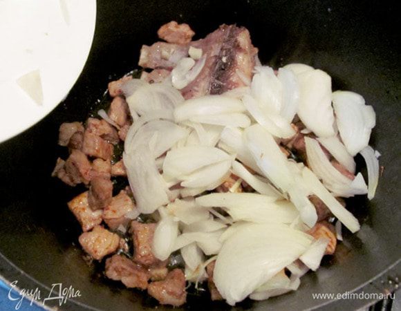 Мясо посолите и добавьте красный перец. К обжаренному мясу положите лук и снова быстро обжарьте до золотистого цвета.