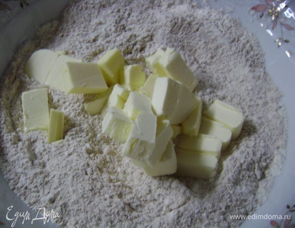 Для теста муку просеять, выложить в нее нарезанное мелким кубиком масло.