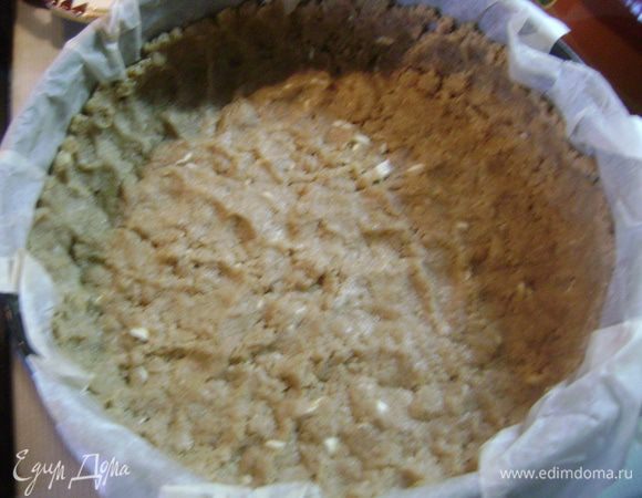 Выложить дно разъемной формы пергаментной бумагой. Раскатать тесто, переложить в форму и сформировать край высотой 2-3 см. Тесто многократно наколоть вилкой. Если тесто перележало и стало твердым, его можно натереть на терке, пальцами сформировать бортики и прижать тесто ко дну и стенкам.