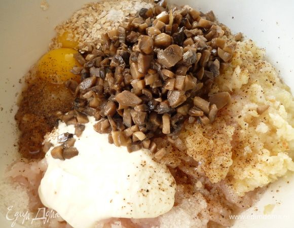 Приготовим фарш: репчатый лук нарезать полукольцами и слегка обжарить его до прозрачности на растительном масле,остудить. Шампиньоны нарезать кубиком (я обжариваю сразу все количество грибов) и обжарить до испарения жидкости,остудить. Рыбное филе пропустить через мясорубку вместе с обжаренным луком, добавить яйца,сметану,овсяные хлопья (или белый хлеб, замоченный в молоке), половину обжаренных шампиньонов, соль и молотый перец.