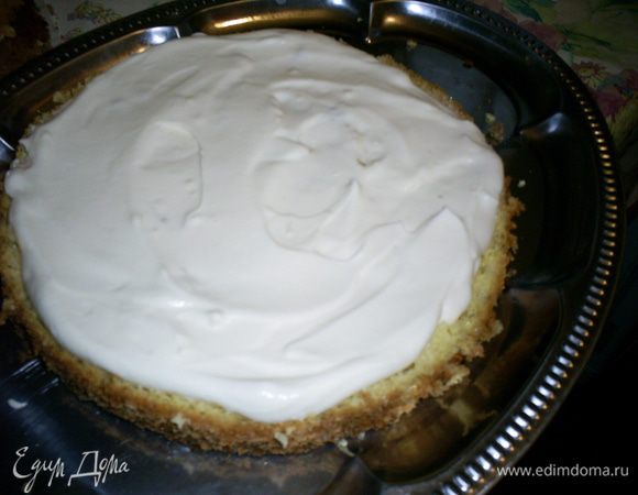 Готовим крем. Сметану взбиваем с сахаром и ванилином до твердых пиков и полного растворения сахара. Если, несмотря на все старания, взбить крем до густоты не получится, не расстраиваемся. Для сборки торта подойдет крем любой консистенции, а густоту крема для украшения поправим с помощью загустителя. Выкладываем на блюдо первый белый корж и щедро смазываем кремом.