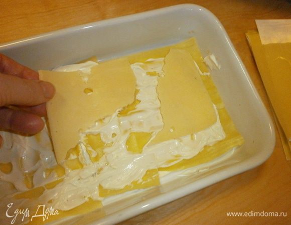 Уложить слоями листы лазаньи, смазать сливочным сыром, уложить пластинки "Эмменталь".