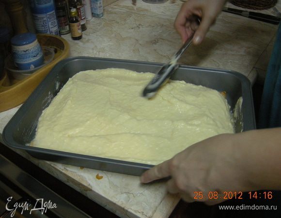 На дно формы укладываем пласт слоеного теста и на него выливаем горячий крем. Разравниваем лопаточкой.