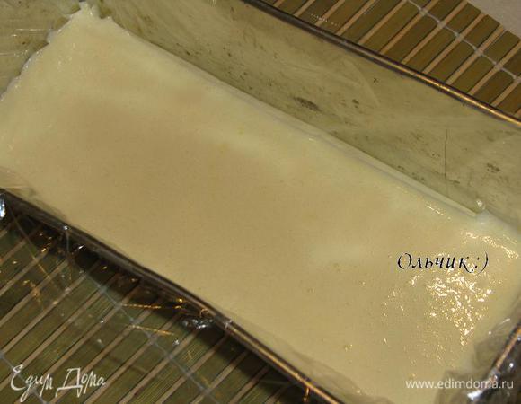 Одну часть желатина распускаем на водяной бане или в СВЧ (до кипения не доводим). Смешиваем распущенный желатин с 1 частью белого шоколадного крема. Взбиваем 100 мл сливок до крутых пик и аккуратно подмешиваем в шоколадную массу. Глубокую прямоугольную форму для кекса выстилаем пищевой плёнкой. Выкладываем подготовленный шоколадный слой, ставим в холодильник на 20-30 минут (или в морозилку на 10-15 минут).