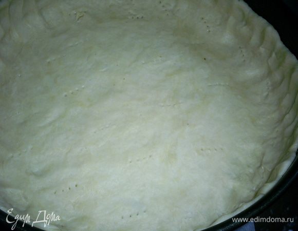 Тесто делим на две неравные части, примерно 1/3 и 2/3. Большую часть теста руками распределяем по форме диаметром 26см, формируя бортики. Тесто наколоть вилкой. Так как тесто жирное, форму можно не смазывать, а дно желательно выстелить бумагой.
