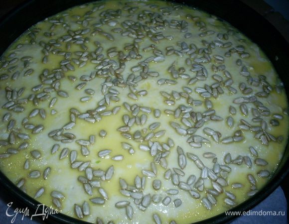 Наполняем начинкой пирог. Оставшееся тесто раскатываем на бумаге или силиконовом коврике и с их помощью осторожно переносим на пирог. Взбитым желтком смазываем поверхность пирога и прокалываем ее в нескольких местах вилкой. Сверху щедро посыпаем  подсолнечными семечками.