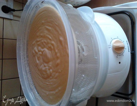 Готовим форму пароварки. У моей пароварки есть ёмкость для варки круп. Её я смазываю сливочным масло и посыпаю панировочными сухарями. Если нет формы для круп, то можно выстелить дно отсека пароварки фольгой. Выливаем творожную массу в форму.  И пароварим один час.