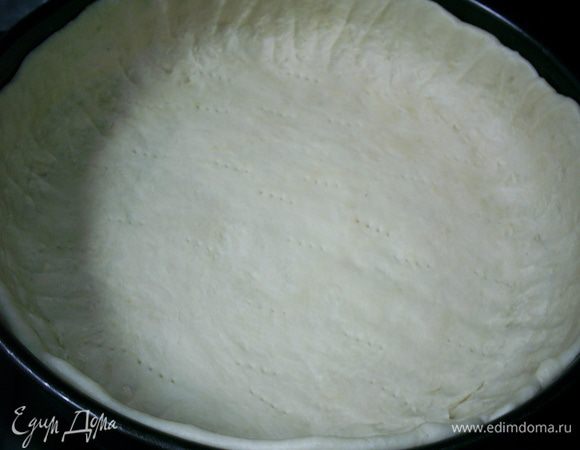 Тесто раскатываем и переносим в разъемную форму диаметром 26 см, формируя бортики. Стенки и дно формы предварительно слегка смазываем растительным маслом. Накалываем тесто вилкой.