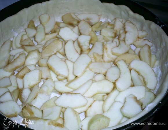Тесто посыпаем крахмалом и выкладываем яблоки, почищенные и порезанные тонкими дольками.