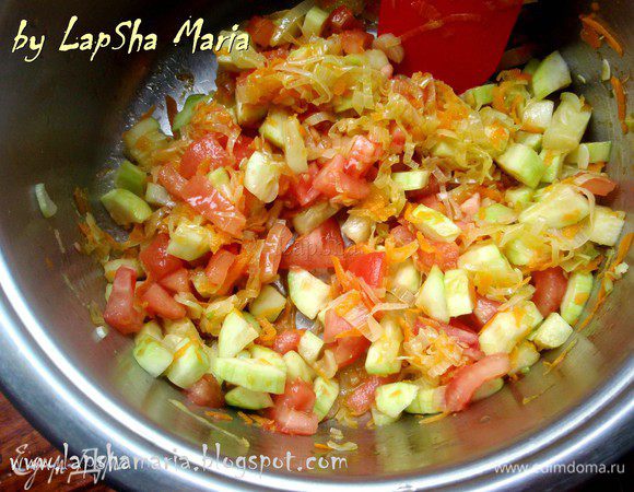 С томата снимем кожицу ножом или ошпарив кипятком. Нарежем его не небольшие кубики и отправим к овощам. Уменьшим огонь и потушим овощи 5 минут.