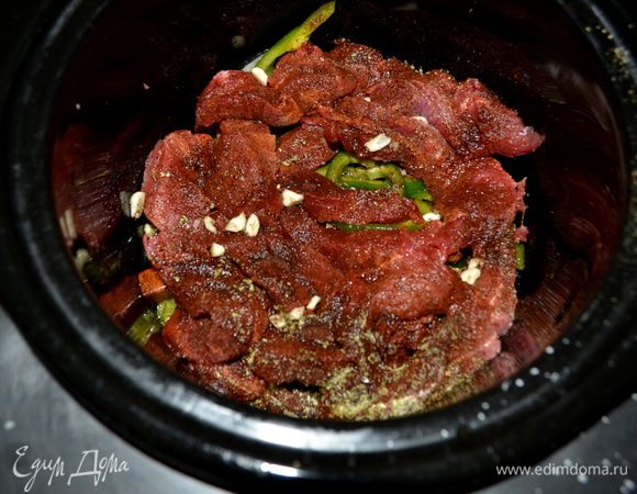 Затем говядину кусками. Сверху обсыпать говядину чили сухим, орегано, соль, чеснок. Сбрызнуть соком лайма. И добавить бульон.