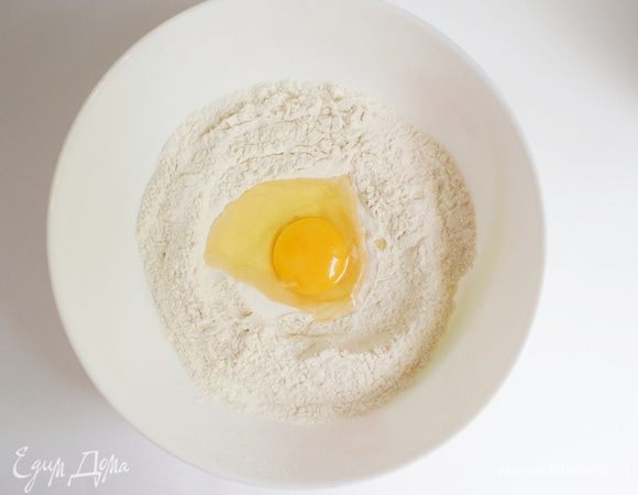 Сделать углубление в центре смеси. Вбить яйцо.
