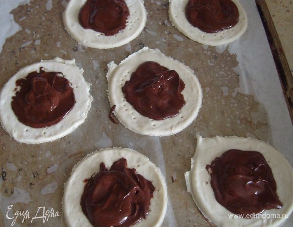 Растопить шоколад на водяной бане или в микроволновке. Растопленным шоколадом смазать тесто.