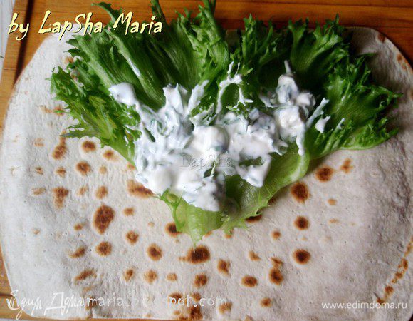 Лепешку прогреть с одной стороны на сухой сковороде. Не передержите лепешку, иначе она может стать твердой и сломается при заворачивании. Греть буквально полминуты, не больше. На подрумянившуюся сторону выкладываем салатные листы (у меня фриссе) и соус. Советую не жалеть соуса, вкусно, когда его много.