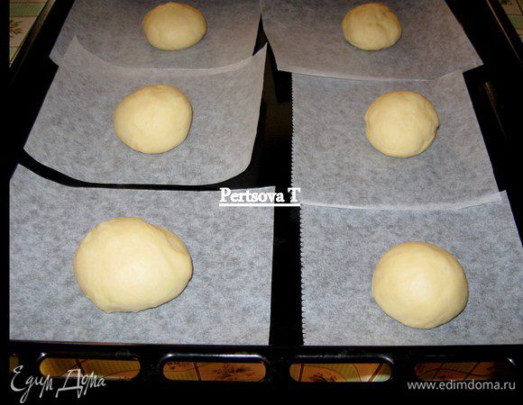 Кладем тесто на рабочий стол и делим на 20 шариков, каждый величиной с грецкий орех.
Из пекарской бумаги вырезаем 20 шт. квадратиков.
На каждый квадратик кладем по одному шарику, накрываем и оставляем подниматься в течение часа.
