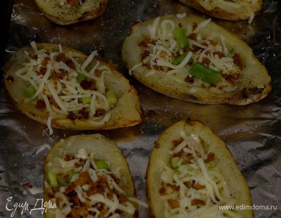 Когда картофель готов, смазать со всех сторон кисточкой каждую половинку олив. маслом, посыпать солью и перцем. Тем-ру духовки увеличить на 230 гр. Поставить картоф. кожурки в духовку на 10 мин. Как они подрумянятся, достать из духовки, заполнить каждую шкурку по 1 ст. л. чеддара и 1 ст.л. Монтерей Джек, беконом, луком. И вернуть в духовку на 5 мин.