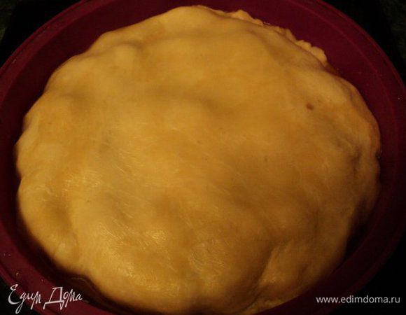 Накрыть тестом яблоки, края теста подоткнуть по краю формы.