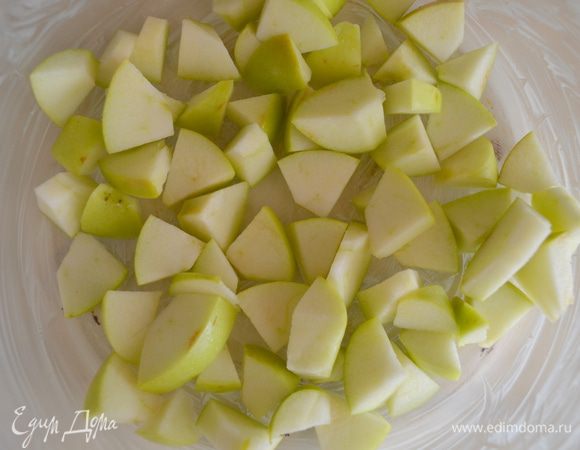 Когда тесто готово, занимаемся начинкой. Яблоки моем, убираем серединку и режем на мелкие кубики, укладываем в форму смазанную сливочным маслом. 