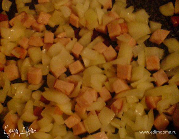 В сковороде разогреть оливковое масло, обжарить окорок. Добавить лук, нарезанный кубиками, и обжарить до прозрачности.