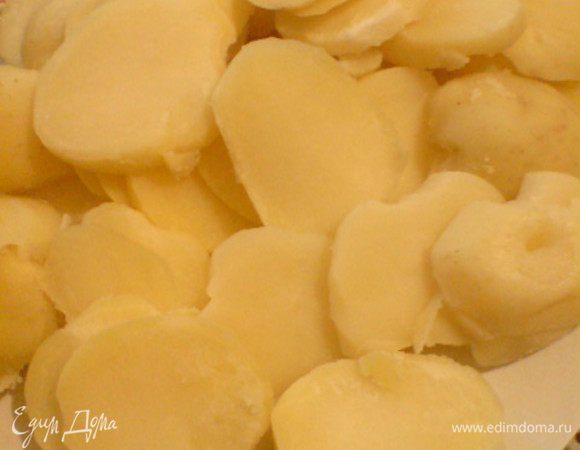 Натереть сыр. Вымыть и нарезать кружочками помидоры. Картошку нарезать ломтиками в 0,5 см. Духовку разогреть до 220 градусов.