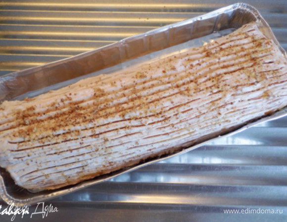 Аккуратно развернуть Рулет и обмазать кремом его внутреннюю сторону.  Опять плотно скатать Рулет, поместить его на блюдо или в форме. Покрыть верх Рулета кремом. Зубчиками вилки на креме нанести полоски и  посыпать миндальной крошкой. Поставить для пропитки на 1 час в холодильник .