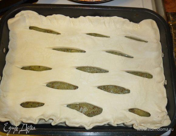 второй пласт теста немного растянуть в длину, сделать на нем надрезы, так, стоб получилась решетка, растянуть теперь и в ширину немного, накрыть начинку, края защипать