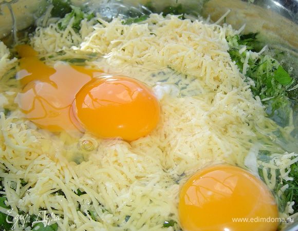 К кабачкам добавляем специи, измельченную зелень, 100 г натертого на мелкой терке сыра, яйца и перемешиваем,