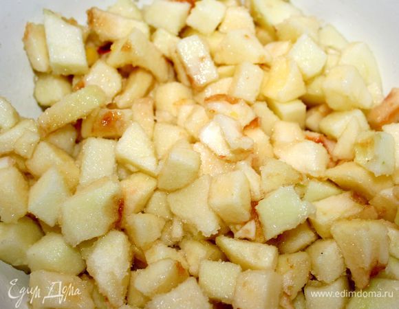 За это время делаем начинку. Яблоки очистить, удалить сердцевину и нарезать небольшими кубиками. Положить в миску, сбрызнуть лимонным соком, натереть цедру, добавить сахар и перемешать.