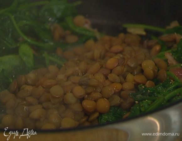 Шумовкой выложить в сковороду к шпинату готовую чечевицу, перемешать, посолить, поперчить и снять с огня.