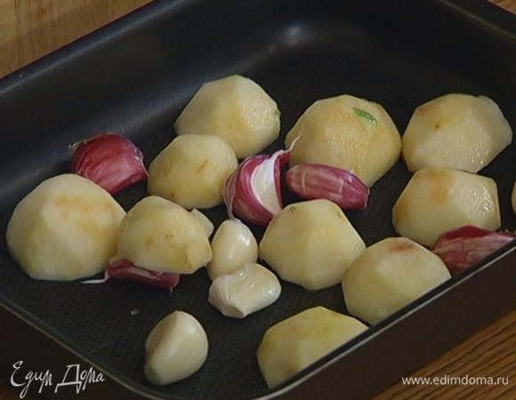 Выложить топинамбур и чеснок в глубокий небольшой противень, посолить, поперчить.