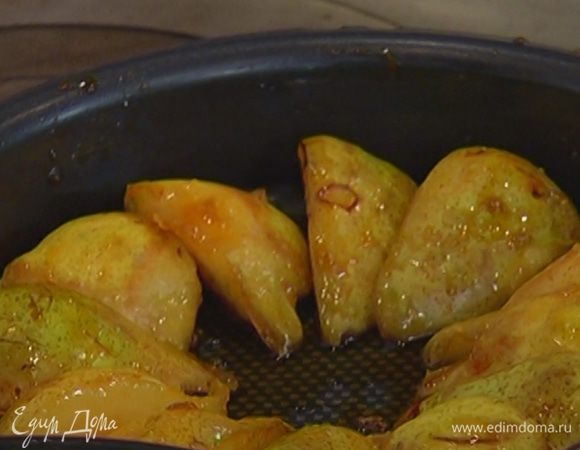 Большую форму для выпечки смазать оставшимся сливочным маслом и шумовкой выложить груши, оставляя между ними немного пространства.