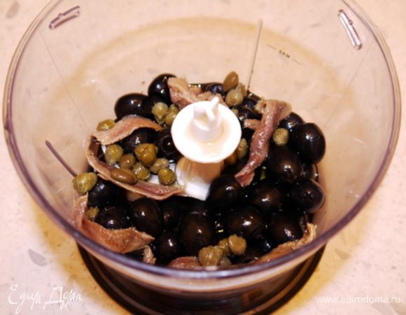 Смыть соль с каперсов Sacla.
Приготовить блендер и поместить в него анчоусы, каперсы, маслины и чеснок. Влить оливковое масло.
Перемолоть содержимое до образования кремообразной однородной массы. При необходимости добавить оливкового масла.
Попробовать и подсолить, если нужно.
Для долгого хранения поместить соус в простерилизованные баночки, влить сверху ещё немного оливкового масла, плотно закрутить крышку и хранить в тёмном прохладном месте, лучше в холодильнике.