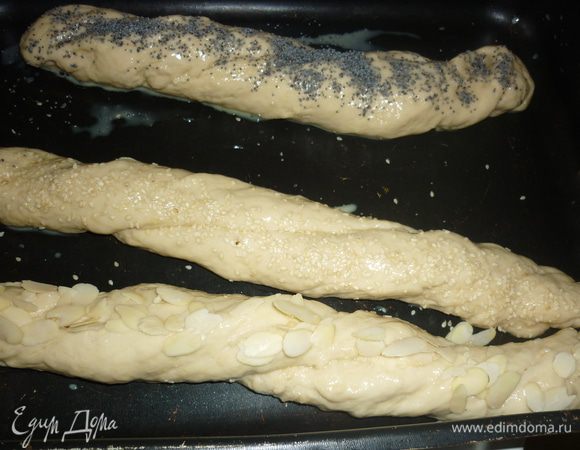 Один жгут посыпать маком, другой — кунжутом, третий — миндальными хлопьями. Чтобы хлопья выглядели после выпечки более привлекательно, их сверху нужно смазать смесью желтка и молока.