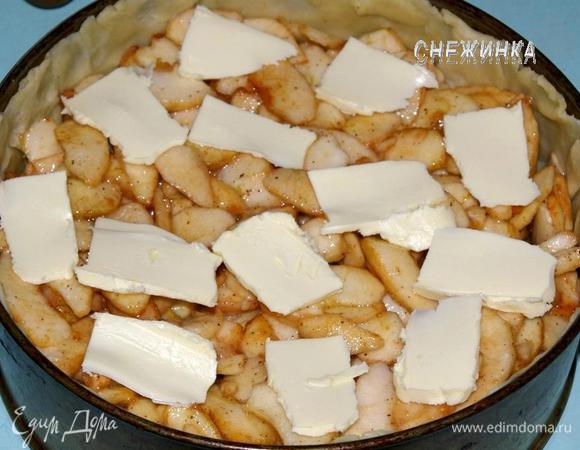 Яблоки отожмите от сока. Добавьте к ним муку, перемешайте. Положите на тесто так, чтобы в центре была небольшая «горочка» из яблок. Сверху распределите тонкие пластинки масла.