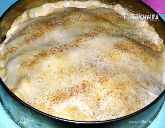 Второй шар теста раскатайте в круг. Накройте им начинку и защипните края. Сверху смажьте молоком, посыпьте сахаром и корицей.