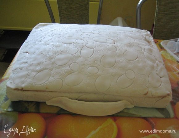 Обтянуть бисквит мастикой,предварительно сделав на ней отпечатки овалов,разного диаметра(я использовала колпачки от фломастера,соломку)
Сделать ремни и застёжки с ручкой.Покрасить в коричневый цвет.Замки я покрыла красителем "Золото".Приятного аппетита!