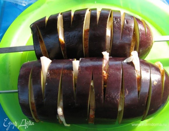 Затем тонко нарезаем сальце (или грудинку, смотря что у вас есть) и аккуратно, проталкивая тупой стороной ножа, вкладываем ломтики сала в прорези баклажана. Чтобы сало легче резалось - подморозьте его.