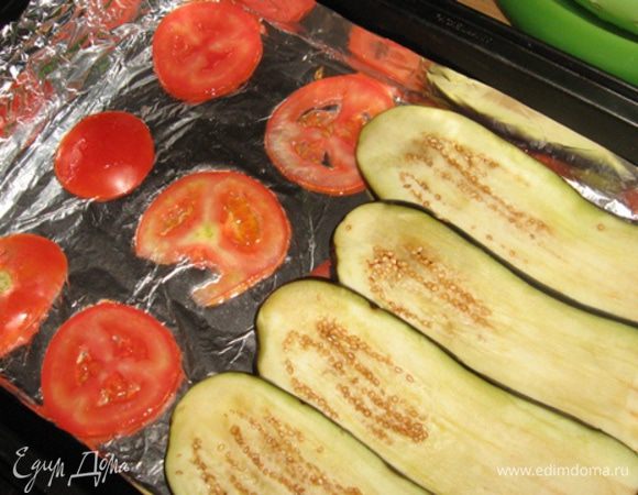 Пока начинка отдыхает, промываем и отжимаем баклажаны. Выстилаем форму фальгой, сбрызгиваем ее маслом и приступаем к выкладке. Если вы, не в пример мне, не выронили баклажаны в раковину и они у вас не перемешались, то перекладывайте дольки баклажан с прослойкой, формируя порционный баклажан. Или же, как я, обратитесь к импровизации... Нижний слой - реденько помидоры (для перестраховки), затем слой баклажан, солим, перчим и выкладываем половину начинки.