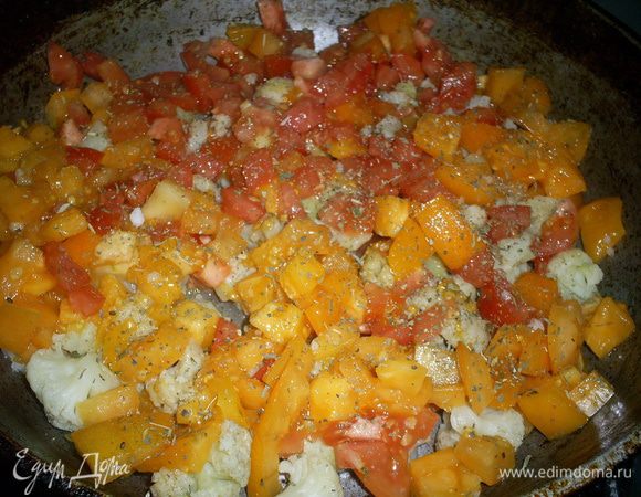 На сковороду с разогретым маслом выкладываем отваренную капусту. Сверху на нее - помидоры. Немного солим наши овощи. Можно посыпать их любимой приправой. Я посыпала Итальянскими травами, что придало блюду восхитительный аромат. Накрываем крышкой и тушим на среднем огне.