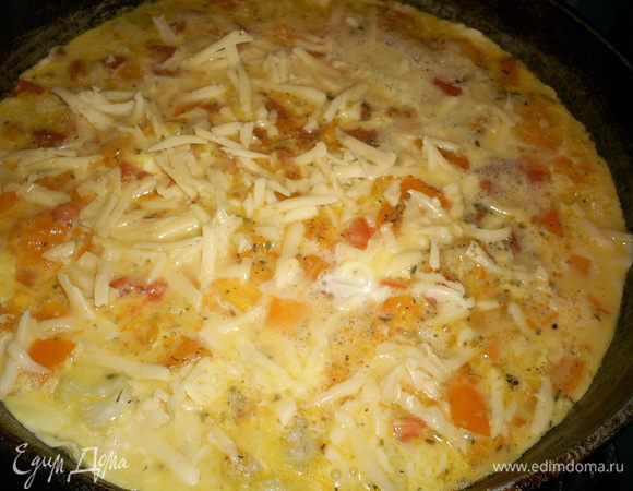 В это время взбиваем вилкой яйца, солим и вливаем молоко. перемешиваем до однородности. Заливаем овощи полученной смесью. сверху посыпаем натертым сыром. Накрываем крышкой и жарим на среднем огне до готовности.