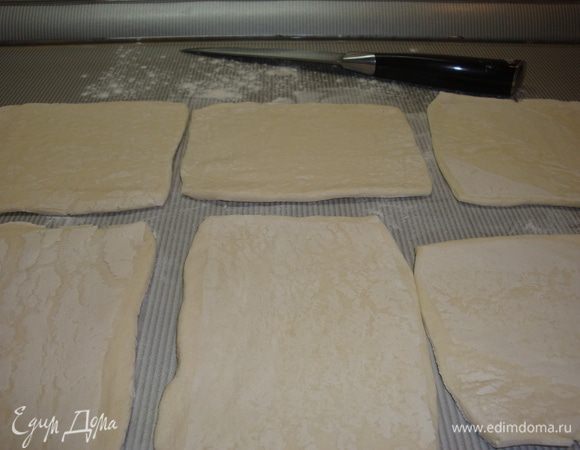 Тесто раскатать, нарезать на 6 частей. В центр каждого положить инжирную "башенку", собирать края теста и защипнуть. Смазать взбитым яйцом.