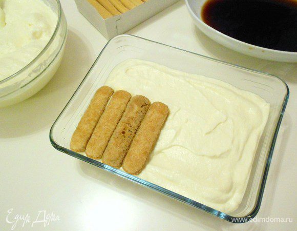 Сверху положить второй слой печенья, пропитанных кофе.